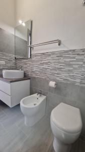 a bathroom with a white toilet and a sink at Via Contu in Iglesias