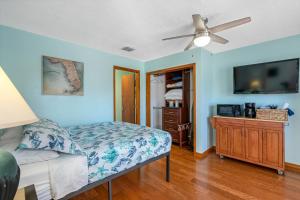 a bedroom with a bed and a flat screen tv at Sand Vista Motel in St Pete Beach
