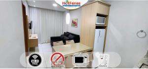 a small living room with a couch and a tv at Everest Flat Service, próx Water Park, Clube Prive, Riviera, Boulevard - HotFérias in Caldas Novas