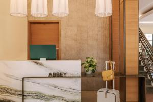 a hotel lobby with a reception desk and a suitcase at Sonder The Abbey in Miami Beach