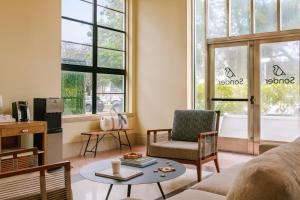 a living room with a couch and chairs and windows at Sonder The Abbey in Miami Beach