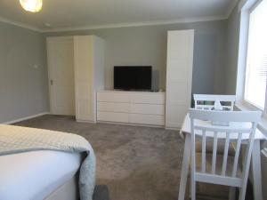 a bedroom with a bed and a flat screen tv at Sgurr Alasdair B&B in Portree