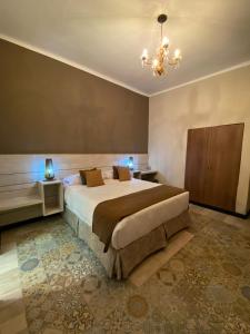 a bedroom with a large bed and a chandelier at OSTATUA ETXEA in Salta