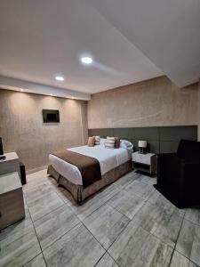um quarto com uma cama grande e um sofá em OSTATUA ETXEA em Salta