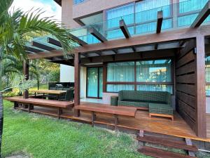 ein Gebäude mit einer Terrasse mit einem Sofa und einem Tisch in der Unterkunft Flat térreo luxo 2qts Carneiros ao lado da igrejinha in Tamandaré