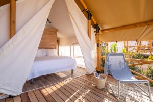 圣塞瓦斯蒂安Wecamp San Sebastián的帐篷内的卧室,配有一张床和椅子