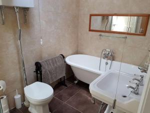 a bathroom with a tub and a toilet and a sink at Stratford Centre, Ground Level, Parking nearby in Stratford-upon-Avon