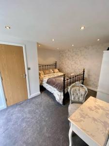 a bedroom with a bed and a chair and a table at Stratford Centre, Ground Level, Parking nearby in Stratford-upon-Avon