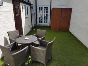 a patio with a table and chairs on the grass at Stratford Centre, Ground Level, Parking nearby in Stratford-upon-Avon