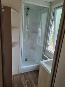 y baño con ducha y lavamanos. en Une petite chambre en forêt à Saint Chéron, en Saint-Chéron