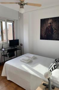 1 dormitorio con 1 cama blanca y una pintura en la pared en Hotel y Restaurante Puerta de Aranda en Aranda de Duero