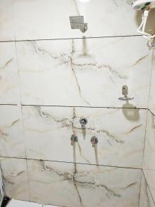 a white marble bathroom with a sink and faucet at Hotel ST INN in Ujjain