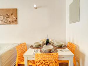 een tafel met stoelen en een witte tafel met borden en glazen bij Espalter White by Hello Homes Sitges in Sitges