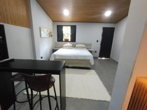 a bedroom with a bed and a table and chairs at Villa São Lourenço in Bertioga