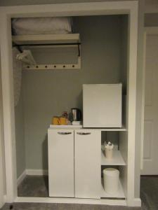 a small kitchen with a refrigerator and a shelf at Sgurr Alasdair B&B in Portree