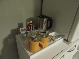 a counter with two yellow mugs and a coffee pot at Sgurr Alasdair B&B in Portree +25 photos
