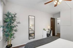a white bedroom with a mirror and a bed at Bright & Airy 1BR Retreat in Hyde Park - Hyde Park 109 and 209 rep in Chicago