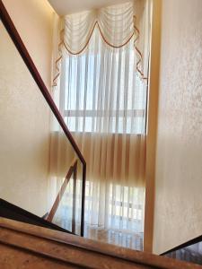 a stairway with a large window with curtains at Mangrove Bay Riverside Hill Riverview B&Bl紅樹灣河畔山河景民宿l毗邻澳門l拱北l華發商都 in Zhuhai