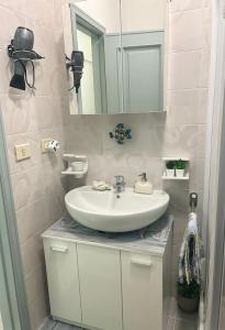 y baño con lavabo blanco y espejo. en LA MANSARDA, en Giardini Naxos