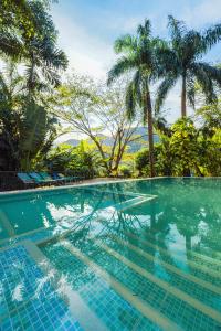 uma piscina com mesa e palmeiras em Casa Cumbres Ecolodge em Yopal