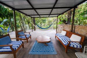 um alpendre com cadeiras, uma mesa e uma rede de descanso em Casa Cumbres Ecolodge em Yopal