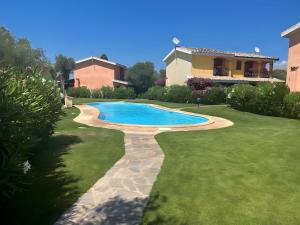 - une piscine dans une cour à côté d'une maison dans l'établissement Villette con piscina zona Porto Pino, à SantʼAnna Arresi