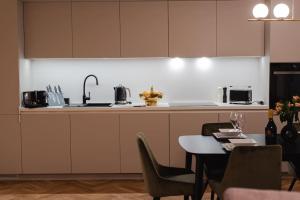 a kitchen with a table with chairs and a sink at Gliwice Dickensa 36A Condo in Gliwice