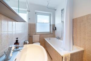 ein Badezimmer mit einer Badewanne, einem WC und einem Waschbecken in der Unterkunft Cityapartment Wagner mit Netlix in Bielefeld