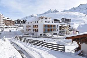 a resort in the snow with buildings at Kühtai Alpensuites in Kühtai