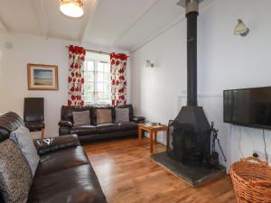 a living room with a couch and a fireplace at Roughtor Cottage in Bodmin