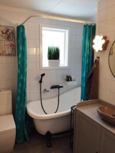 een badkamer met een bad, een toilet en een wastafel bij Som hemma in Grästorp