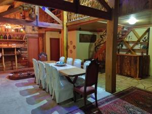 a dining room with a table and white chairs at Fazenda e Vinícola ABN in Andrelândia
