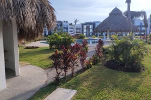 アカプルコにあるDepto. con club de Playaのプールと建物のあるリゾートの景色を望めます。