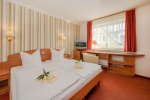 una camera d'albergo con 2 letti e una scrivania di Gasthaus & Pension Natzke a Usedom Town