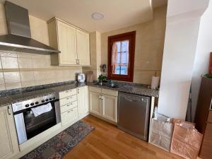 uma cozinha com armários brancos e electrodomésticos de aço inoxidável em Apartamento entero en la Vall Fosca em La Pobleta de Bellvei