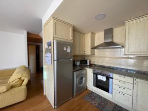 a kitchen with a stainless steel refrigerator and a couch at Apartamento entero en la Vall Fosca in La Pobleta de Bellvei