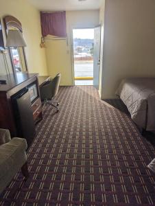 a hotel room with a bed and a desk and a chair at Dollar Inn in Somerset