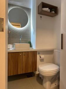 a bathroom with a toilet and a sink and a mirror at Studio 1111 in Rio de Janeiro