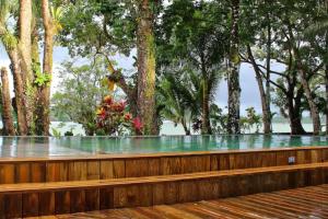 a wooden bench with trees in the background at Luxurious entire country house in Rio Dulce, Guatemala in Rio Dulce +4 photos