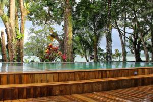 a wooden bench on a deck with trees in the background at Luxurious entire country house in Rio Dulce, Guatemala in Rio Dulce
