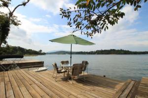 a table and chairs on a dock with an umbrella at Luxurious entire country house in Rio Dulce, Guatemala in Rio Dulce