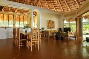 a dining room and living room with a table and chairs at Luxurious entire country house in Rio Dulce, Guatemala in Rio Dulce