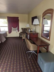 um quarto de hotel com uma secretária e uma cama em Dollar Inn em Somerset