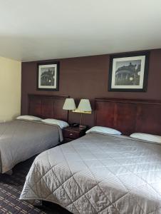 a hotel room with two beds and two lamps at Dollar Inn in Somerset