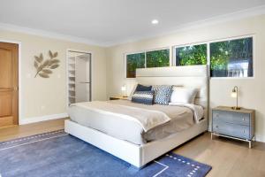 a white bedroom with a large bed and two windows at Forman by AvantStay Pool Near Hollywood Studios in Burbank
