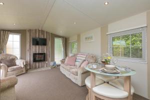 a living room with a couch and a table at Lazy Lodge in Redruth