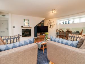 a living room with two couches and a tv at Ebenezer Cottage in Marazion