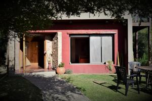 ein rotes Haus mit einem Tisch und Stühlen im Hof in der Unterkunft Moradillo Apart in La Cuesta