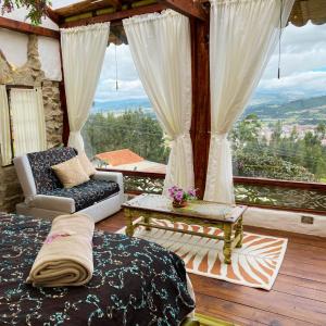 a living room with a balcony with a view at Cabaña Esmeralda - Seilan Alojamiento Rural in Paipa
