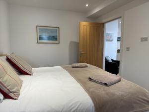 a bedroom with a large bed with two towels on it at The Pilot Boat Inn, Isle of Wight in Bembridge